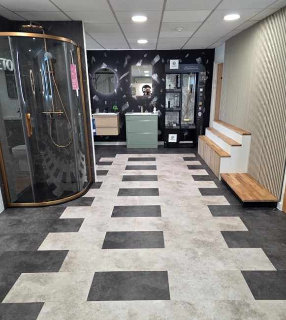 Showroom shower display area with gold quadrant enclosure, vanity feature wall and timber bench in Tamworth